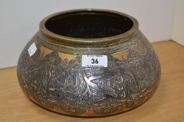 An Eastern Mamluk style white metal and brass bowl, decorated with scripture and motifs, 13cm high
