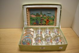A 1950s Japanese tea set, comprising six hand painted glasses, saucers, and displayed within an
