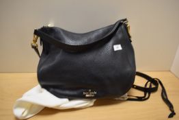 A Kate Spade, New York black leather handbag with dust cover.