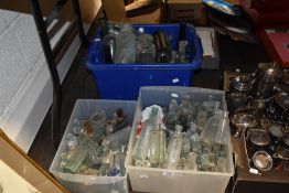 Two boxes of vintage and antique glass bottles, including medicine bottles and sauce bottles.