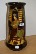 A 20th century brown moulded vase, having depiction of traditionally dressed gent leaning against
