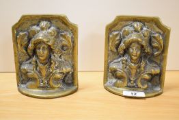 A pair of Victorian relief moulded brass bookends, decorated with figural busts, 14cm high