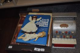 A vintage Codeg toy till and a selection of doll collectors books.