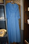 A vintage 1970s pale blue maxi dress, having belt and ruffled cuffs.