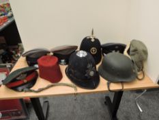 An assortment of Helmets and Peaked Caps 8 in total, one is a German Steel Helmet