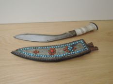 A Kukri Knife having decorated bone handle, blade slightly decorated, beaded and wire decorated