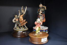 Three vintage musical figurines, including Reuge Swiss made clown with horn.