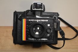 Two cameras. A Polaroid Colour Swinger instant camera and a Hanimex 35AFX camera
