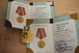 A Soviet Union Navy Officer hat badge and two Soviet passport covers