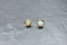 A pair of opal earrings of circular form in 9ct gold collared mounts
