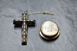 A tortoise shell cross pendant having gold pique decoration and a conch shell cameo brooch depicting