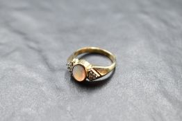 An opal dress ring having a trio of diamond chips to each shoulder on a 9ct gold moulded loop,