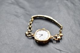 A lady's vintage 9ct gold wrist watch having Arabic numeral dial to white face in plain case on a
