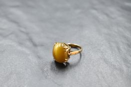 A tigers eye cabochon stone ring in a four claw mount on a 9ct gold loop, size F & approx 4g