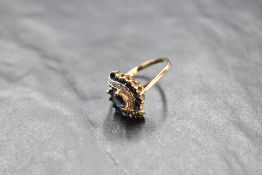 A sapphire and diamond open swirl cluster in a claw set basket mount on a 9ct gold loop, size Q &