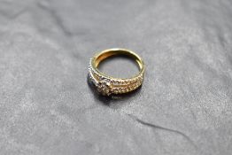 A yellow metal diamond set ring, the central flower head arrangement of brilliant cut diamonds