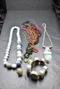 A small selection of jewellery including four strings of glass beads, three pieces of silver and