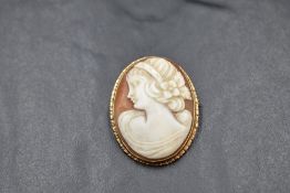 A conch shell cameo brooch depicting a maiden in profile in a 9ct rose gold mount, approx 8.3g