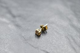 A single diamond stud earring, approx 0.25ct in a claw set yellow metal mount, no marks