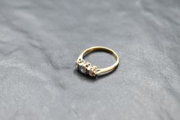 A diamond trio ring, total approx 0.15ct in an illusionary mount on a yellow metal loop stamped