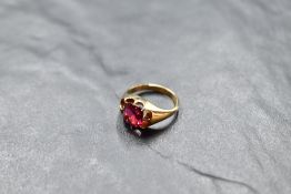 A yellow metal signet ring set with a square ruby, approx 1.5ct in a multi claw mount, no marks