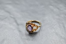 An amethyst solitaire ring in an open bark effect claw set mount on a 9ct gold loop, size N & approx