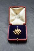 An Edwardian seed yellow metal star burst brooch/pendant stamped 15ct decorated with split seed