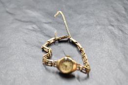 A lady's 9ct gold wrist watch by Avia having baton and Arabic numeral dial to small face in plain