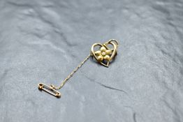 A yellow metal heart shaped brooch stamped 15ct having seed pearl floral decoration, approx 3.4g