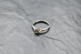 A diamond solitaire ring, approx 0.5ct in a claw set collared mount on a white metal loop stamped