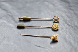 Three yellow metal tie pins, stamped 15 & 9ct, having fox head, seed pearl and diamond decoration,