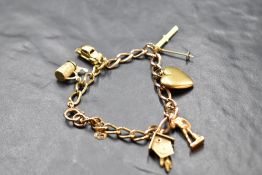 A 9ct gold charm bracelet having six yellow metal charms including two 18ct gold (skis & cuckoo