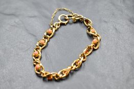 A yellow metal bracelet stamped 9ct having cabochon coral insets, approx 10g