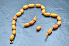 A broken string of egg yolk amber beads of equal oval form, approx 16' & 22g