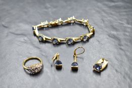 A three piece set of gold plated silver jewellery having blue stones, and a matched gold plated