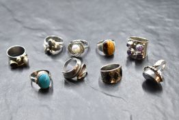 Nine silver and white metal rings of various forms including turquoise, tigers eye, Artisan style