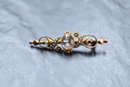 A 9ct rose gold bar brooch having central pale amethyst within a seed pearl set decorative mount,
