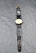 A lady's yellow metal Omega wrist watch having baton numeral dial to champagne face in plain case on