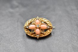 A Victorian coral and diamond set brooch of star form within an open gold moulded border, no
