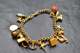 A 9ct gold charm bracelet having dog leash clasp and seventeen yellow metal and 9ct gold charms