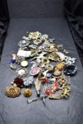 A selection of costume jewellery brooches including enamelled, Scottish thistle etc