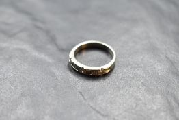 A 14k white metal and diamond set ring, having a linear arrangement of pressure-set diamond