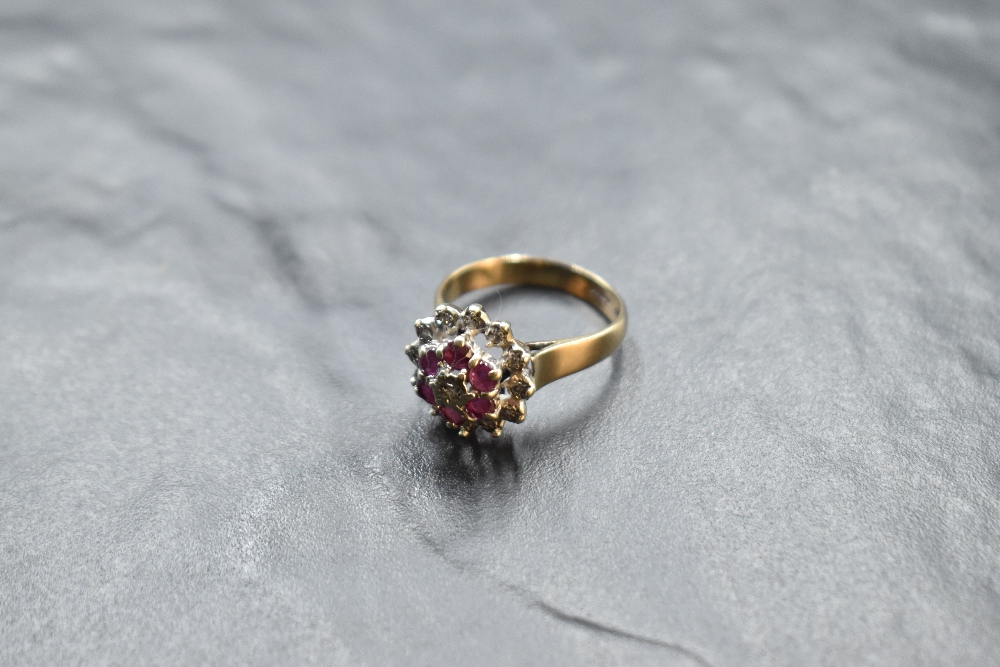 A ruby and diamond chip triple cluster ring having a claw set and illusionary mount on a 9ct gold