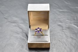 An amethyst and diamond daisy cluster ring having claw set basket mount and 18ct gold loop, size S &
