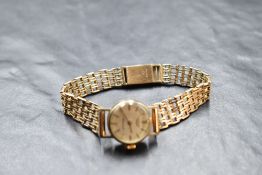 A lady's 9ct gold wrist watch by Longines having a baton numeral dial to champagne face in a plain