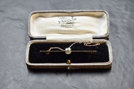 A yellow metal bar brooch with central diamond, approx 1ct, with safety chain, approx 4.8g