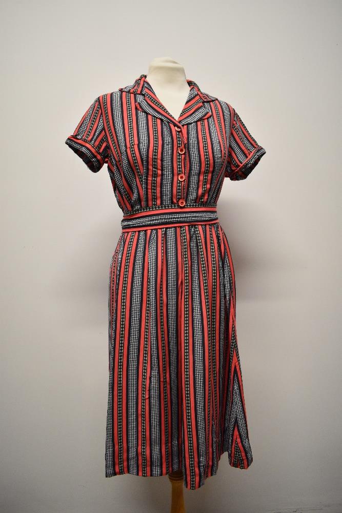 A 1950s cotton day dress of pink cotton with black dog tooth pattern, having cap sleeves, button