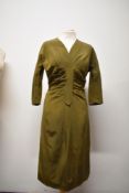 A 1950s olive green grosgrain Kitty Copeland dress, having half belt to back and rusched bodice.