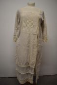 A vintage linen smock or over dress, having lace and crochet detailing and side button fastening.