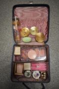 A vanity case containing an assortment of vintage cosmetics, most unused, rollers, perfume, compacts
